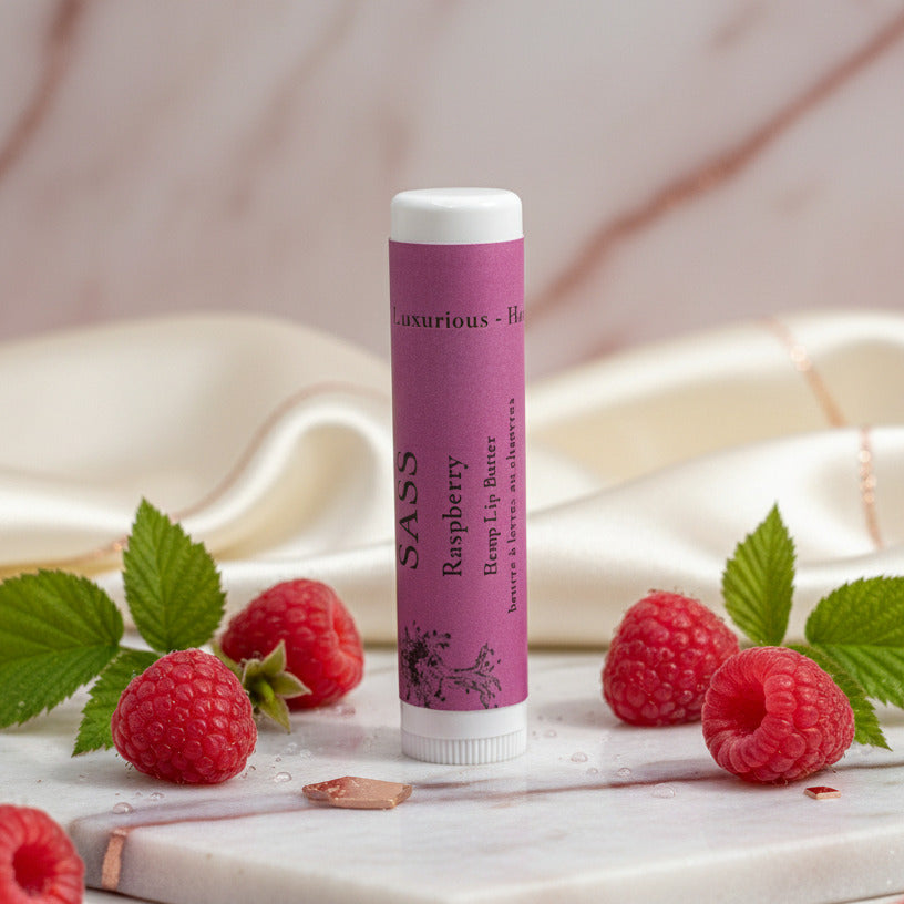 Lip balm tube with raspberries and leaves on a marble surface