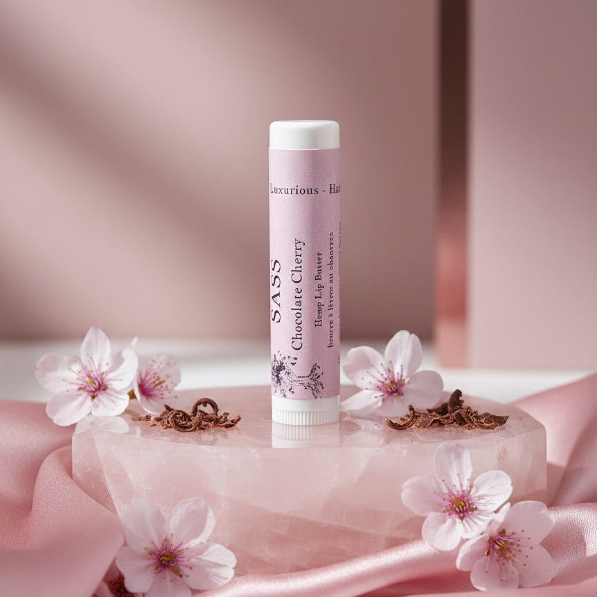 Lip balm with flowers and pink fabric on a soft pink background