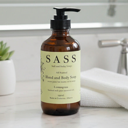 Bottle of SASS hand and body soap on a white surface