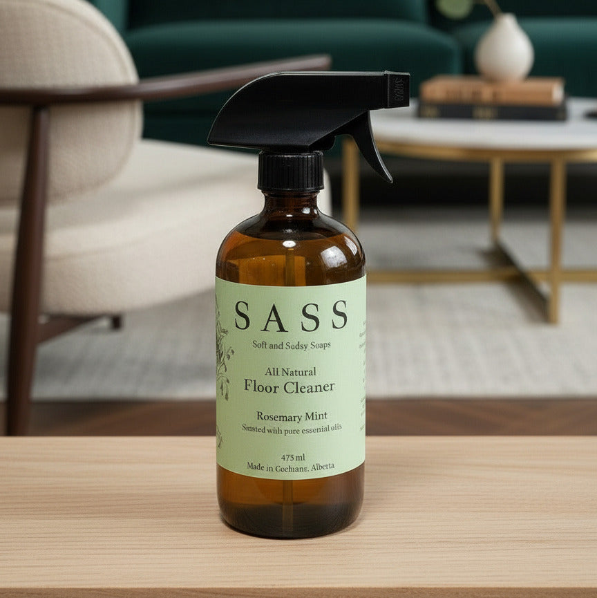 SASS all natural floor cleaner bottle on a wooden surface with a blurred background