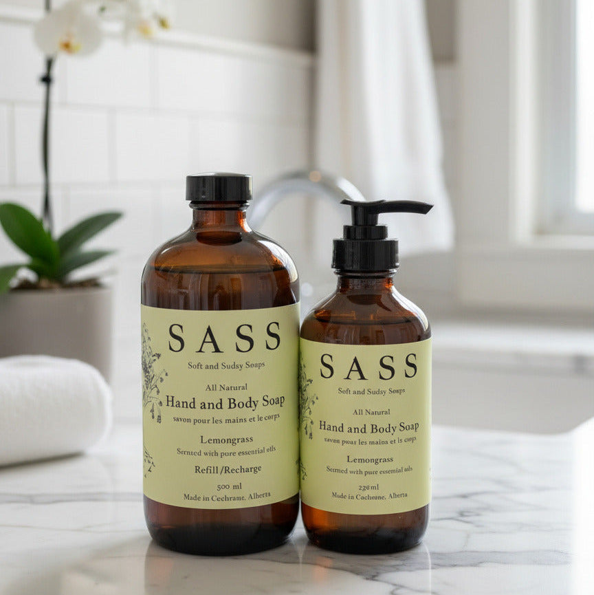 Two bottles of SASS hand and body soap on a luxury bathroom background