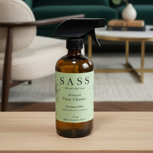 SASS all natural floor cleaner bottle on a wooden surface with a blurred background